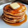 fluffy eggless pancakes topped with butter and maple syrup.