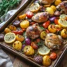 Colorful sheet pan dinner with roasted chicken, vegetables, and herbs, made with just 5 ingredients on a baking tray.