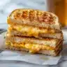 chaffle sandwich with deli meat and cheese on a rustic plate.