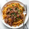 A luscious skillet of Mongolian beef noodles with tender beef, bright broccoli, and sesame seeds.