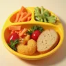 Colorful kids' lunch featuring a smiling sandwich with cheese and vegetable face, a cup of fresh fruit, baby carrots shaped like stars, and a small container of dip, all arranged in a bright lunchbox on a playful placemat.